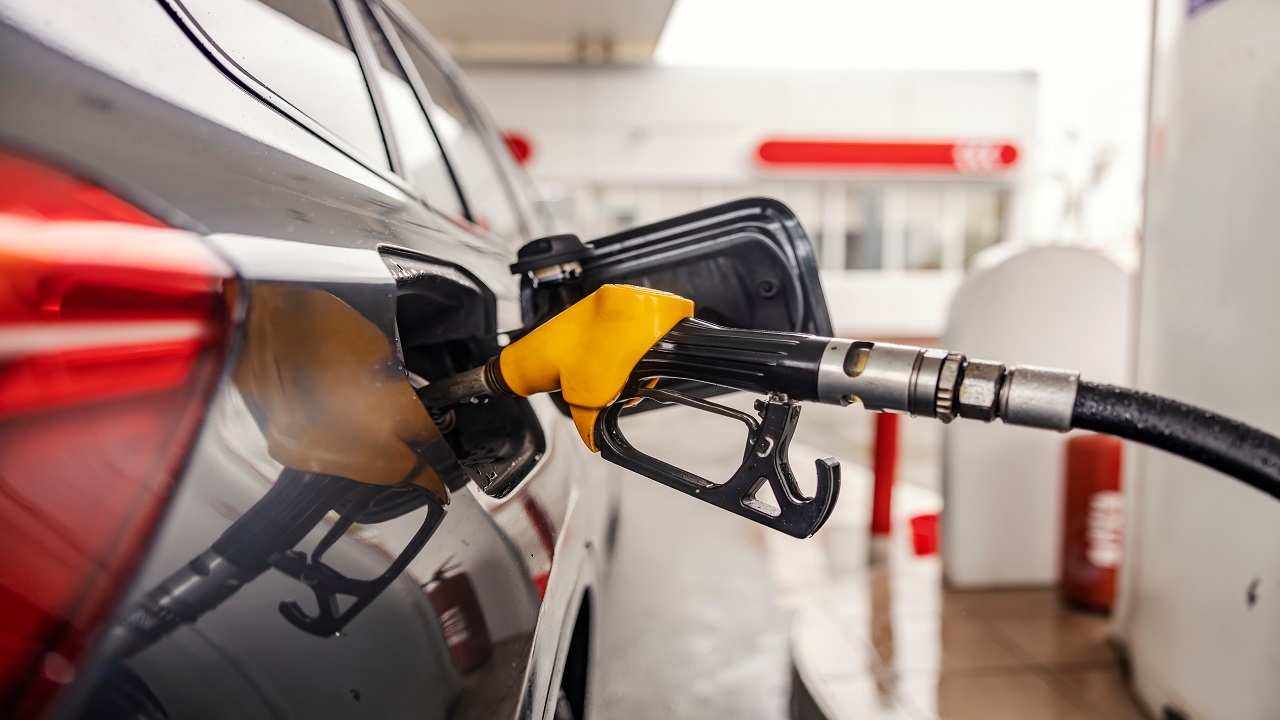 Fuel nozzle, gasolibe pump filling a vehicle tank at a gas station
